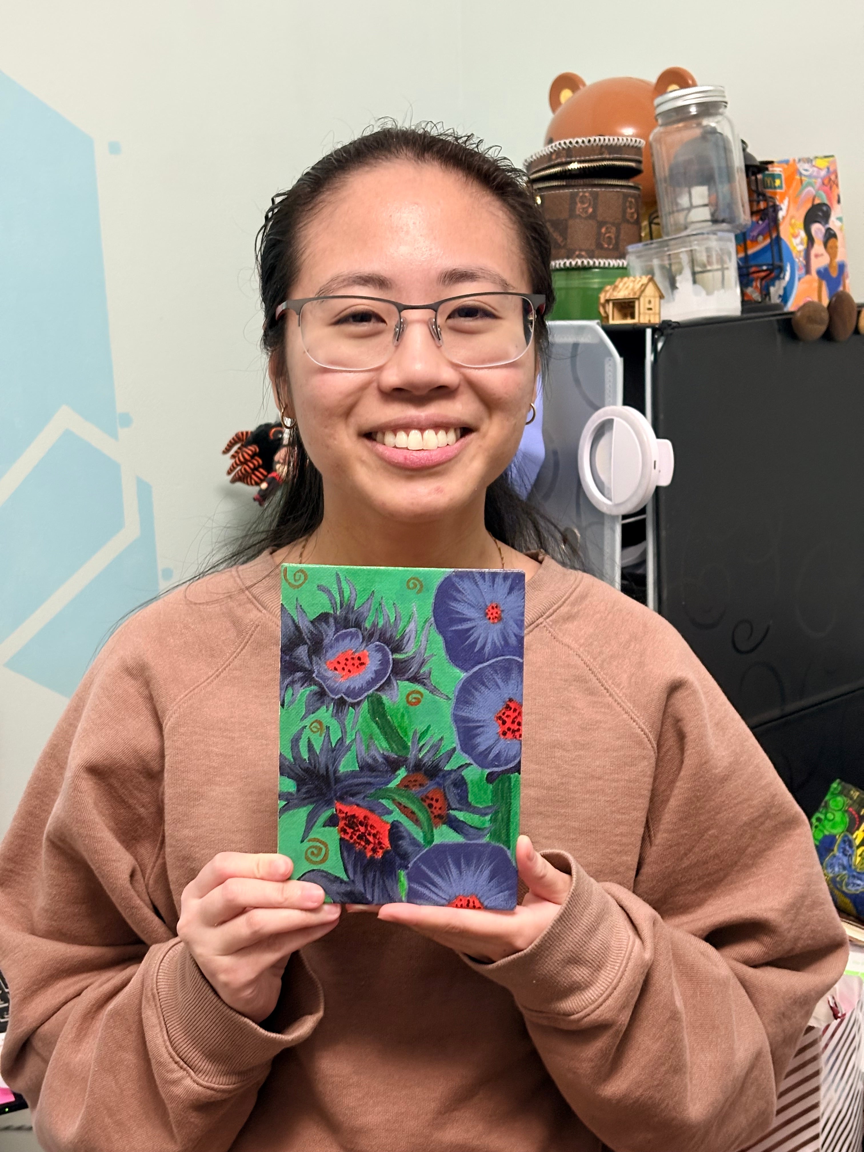 Jessie holding a card with floral design in an indoor setting