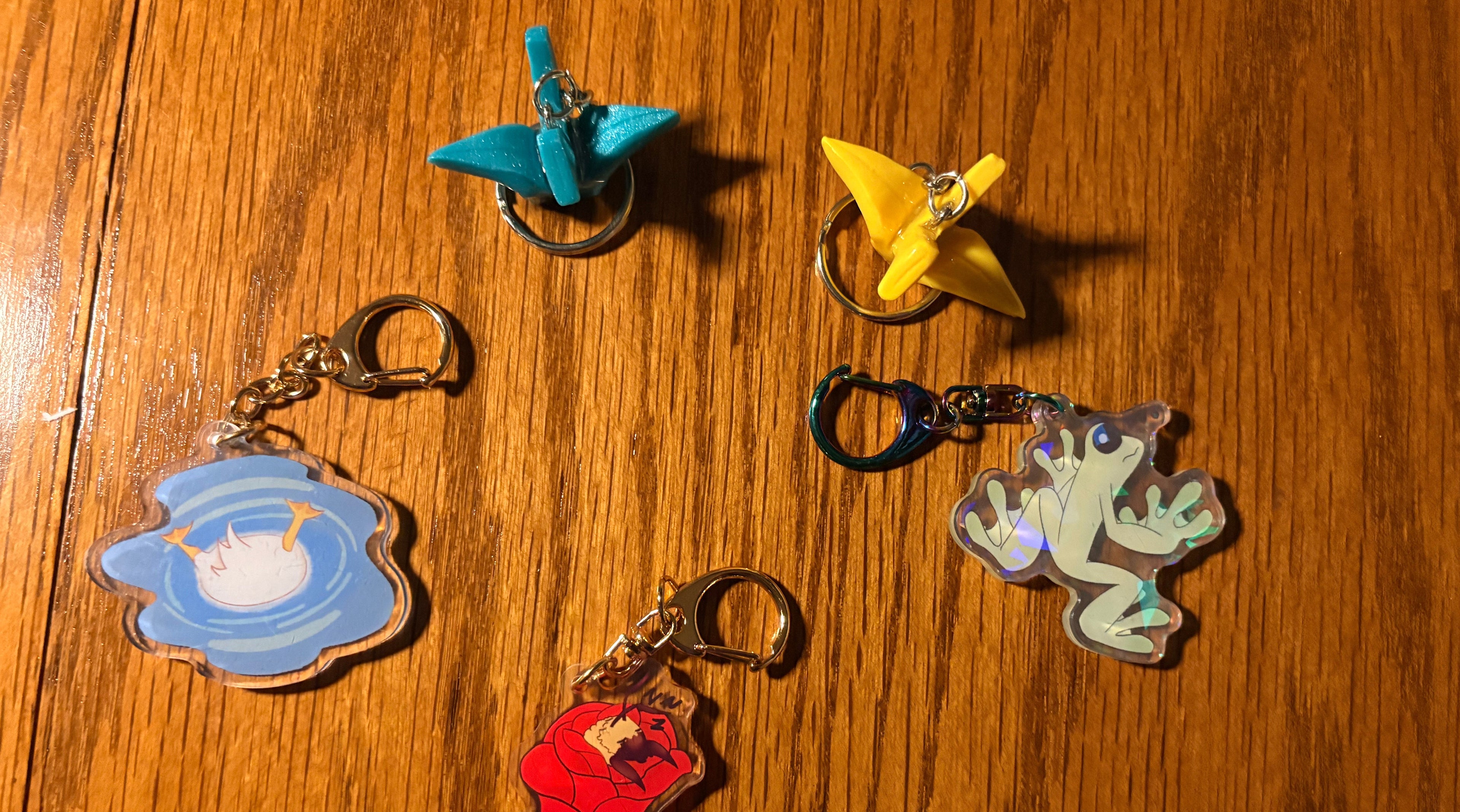 Five colorful keychains on a wooden surface