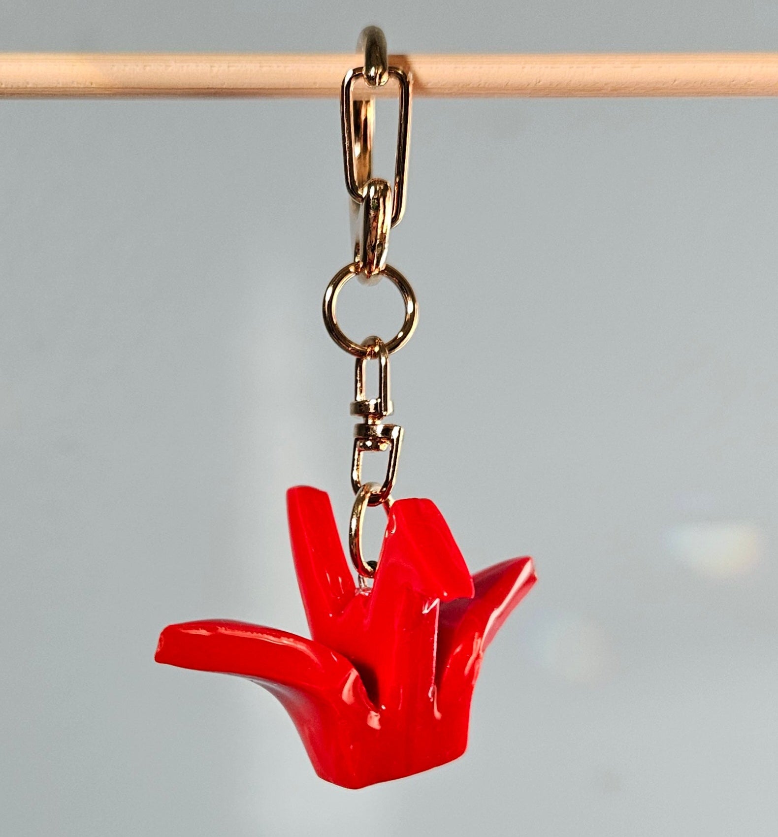 Red origami crane keychain on a clear background