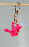 Pink keychain with gold clasp on a gray background