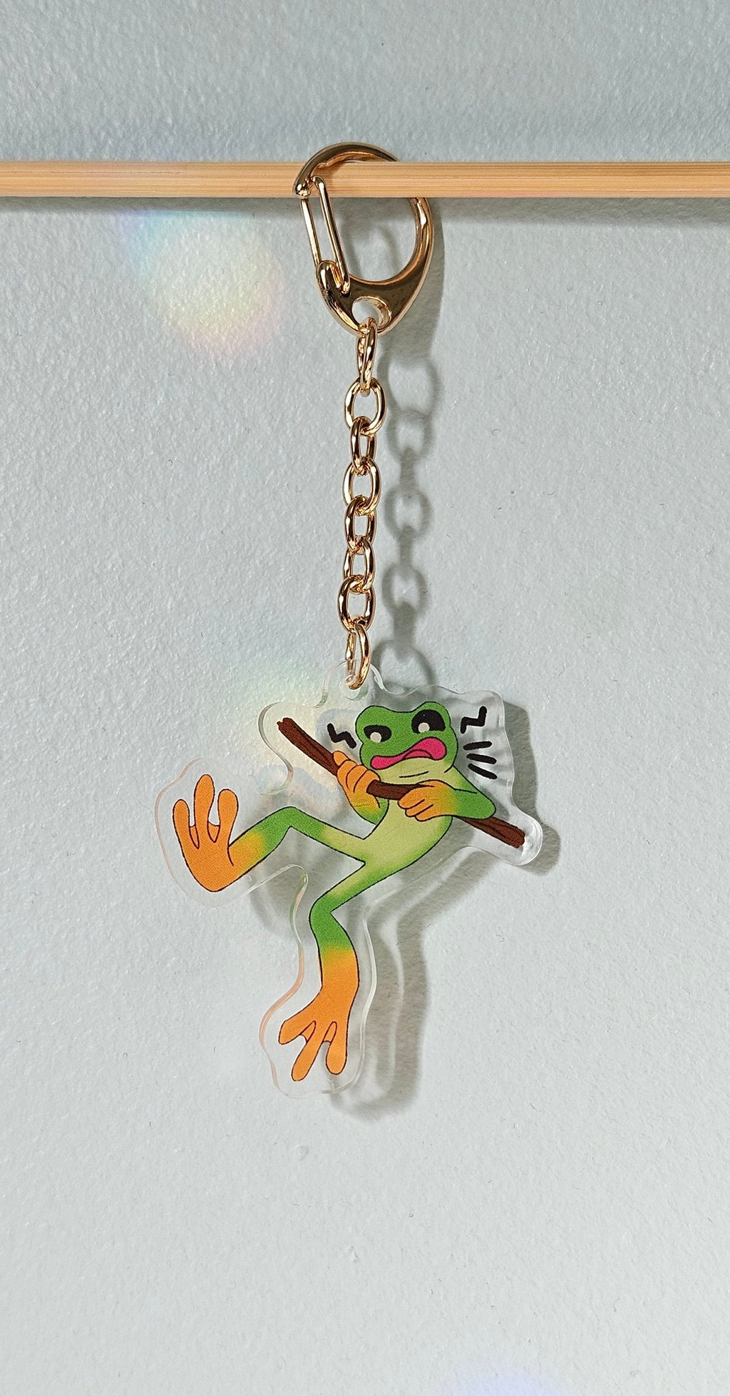 Keychain with a cartoon frog design on a light gray background