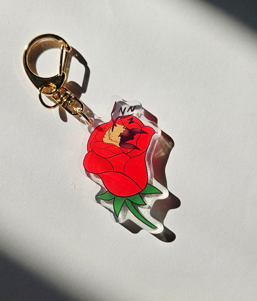 Keychain with a cartoon character holding a red rose on a light gray background