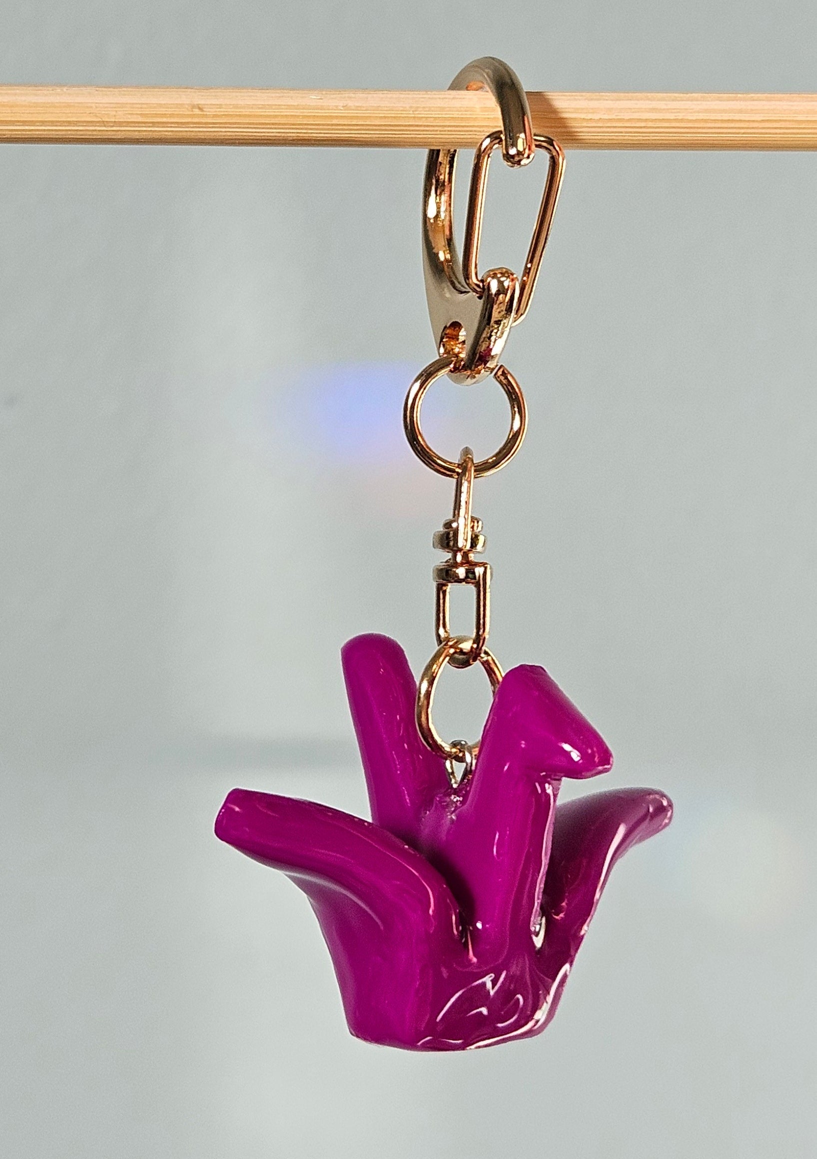 Purple hand-shaped keychain on a gray background
