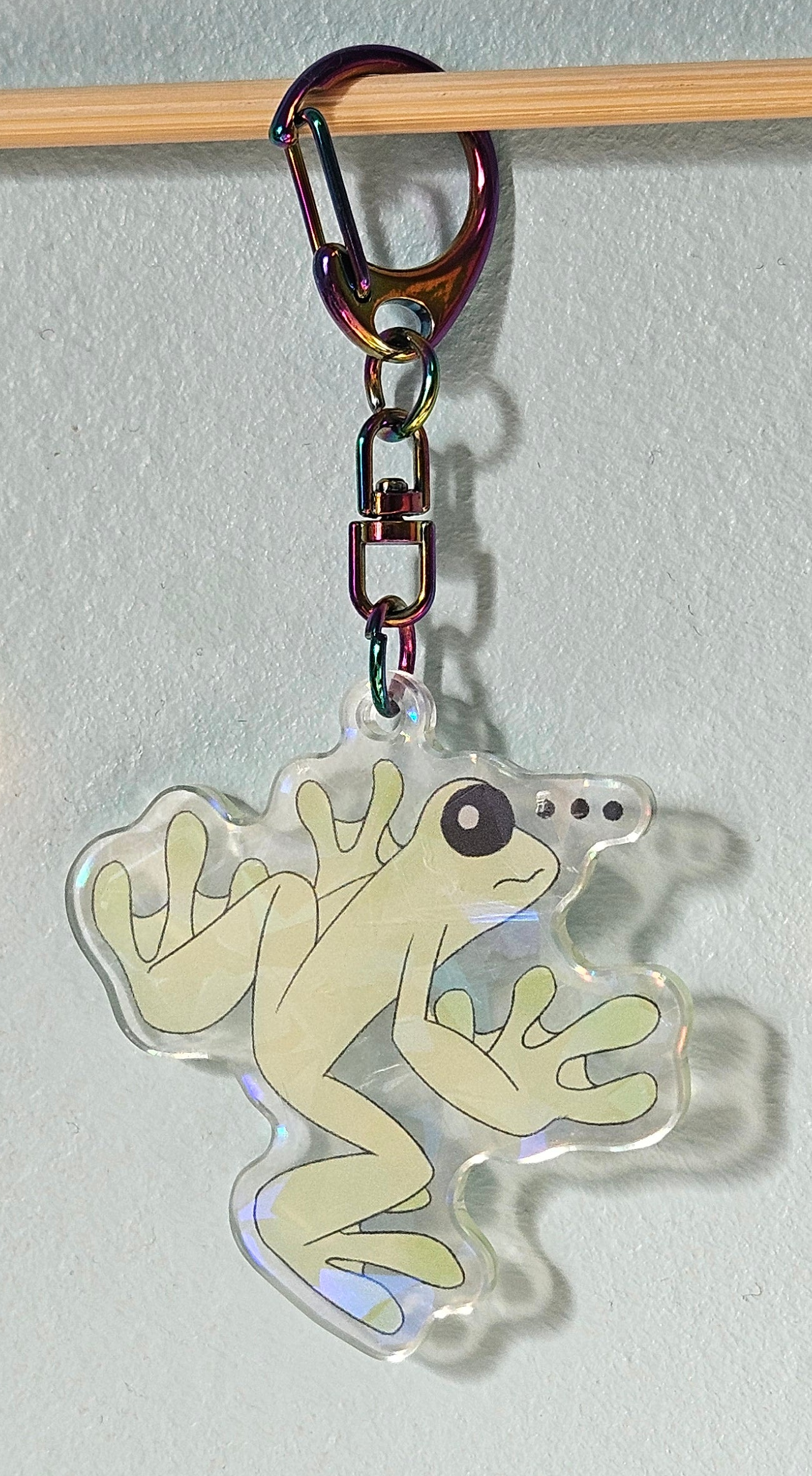 Frog-shaped keychain with a carabiner on a light gray background