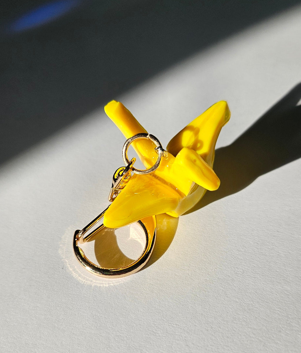 Yellow polymer clay crane keychain with neutral background