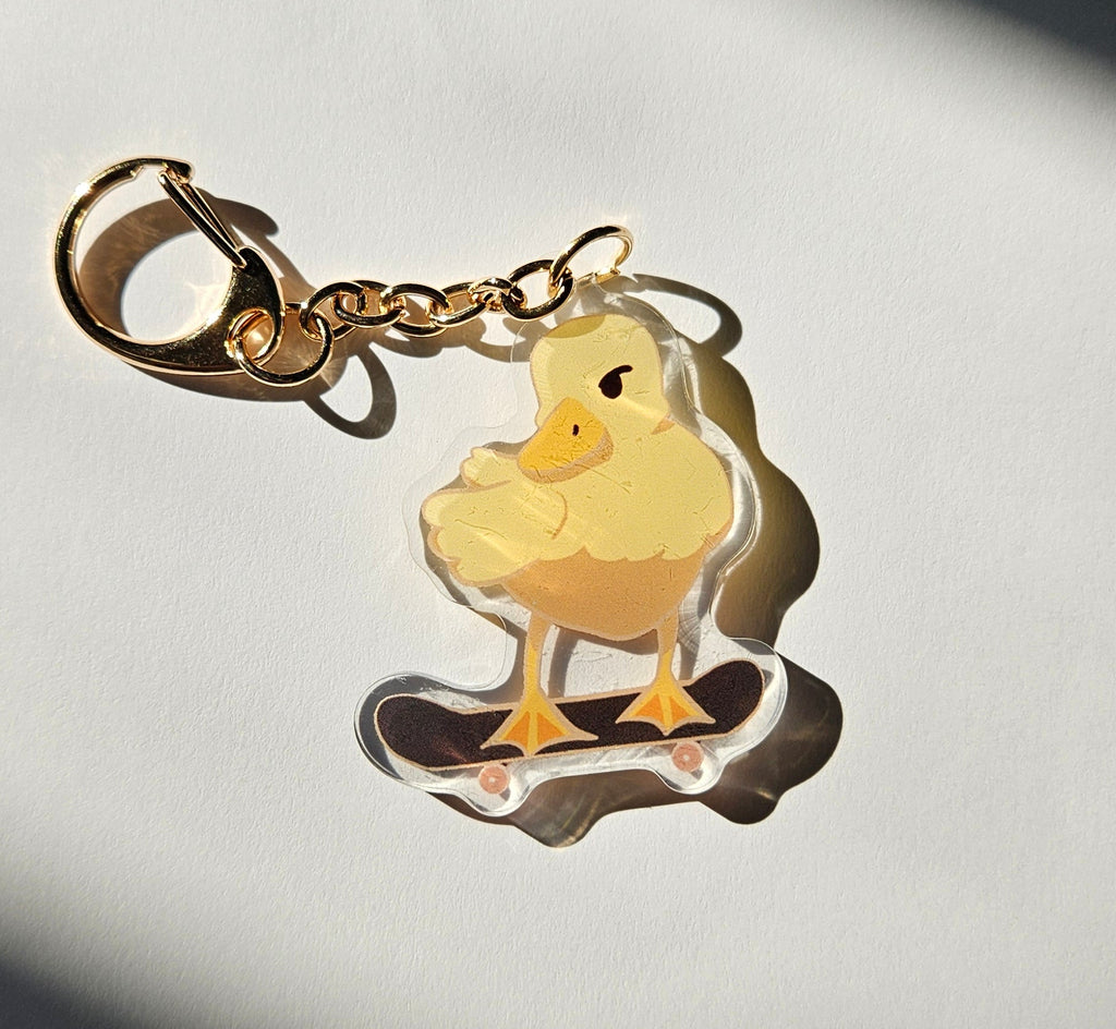 Duck on a skateboard keychain on a grey background