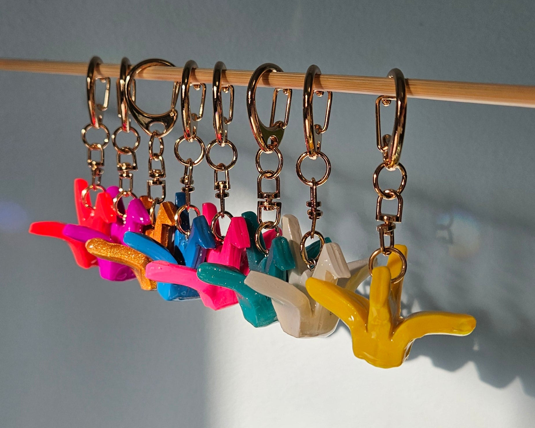 Colorful crane keychainson a stick against a gray background