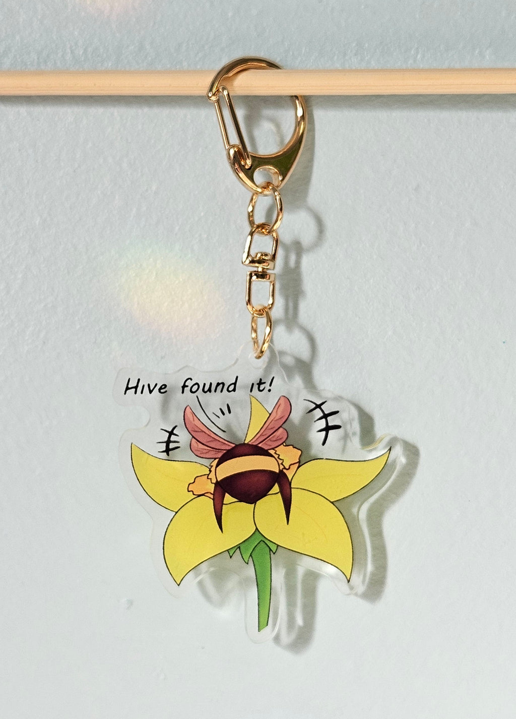 Keychain with sunflower design and text on a light gray background