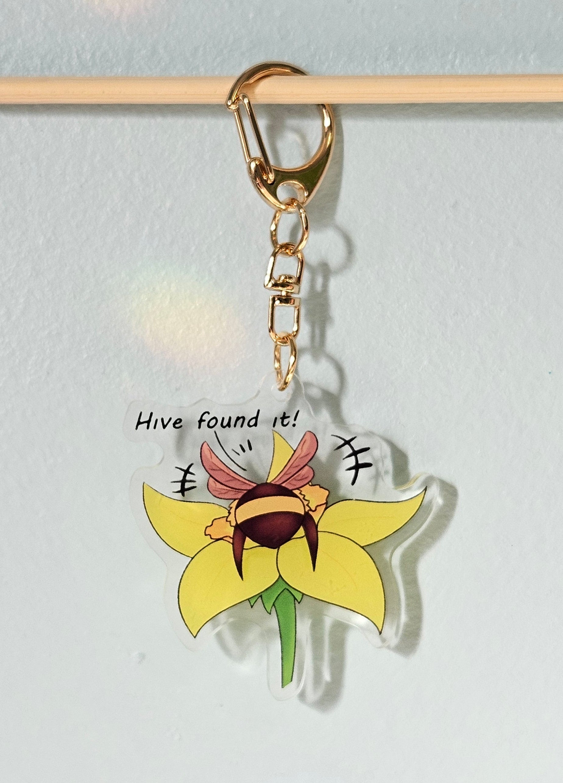 Keychain with sunflower design and text on a light gray background